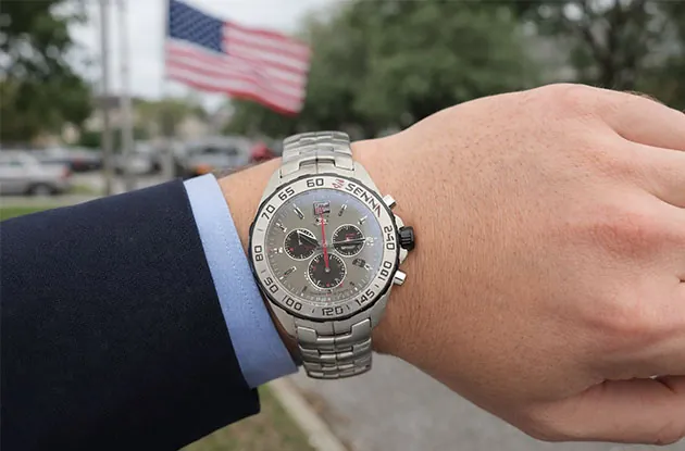 Luxury TAG Heuer Senna chronograph watch on a man's wrist with a navy suit, showcasing a stylish American business look and premium stainless steel design