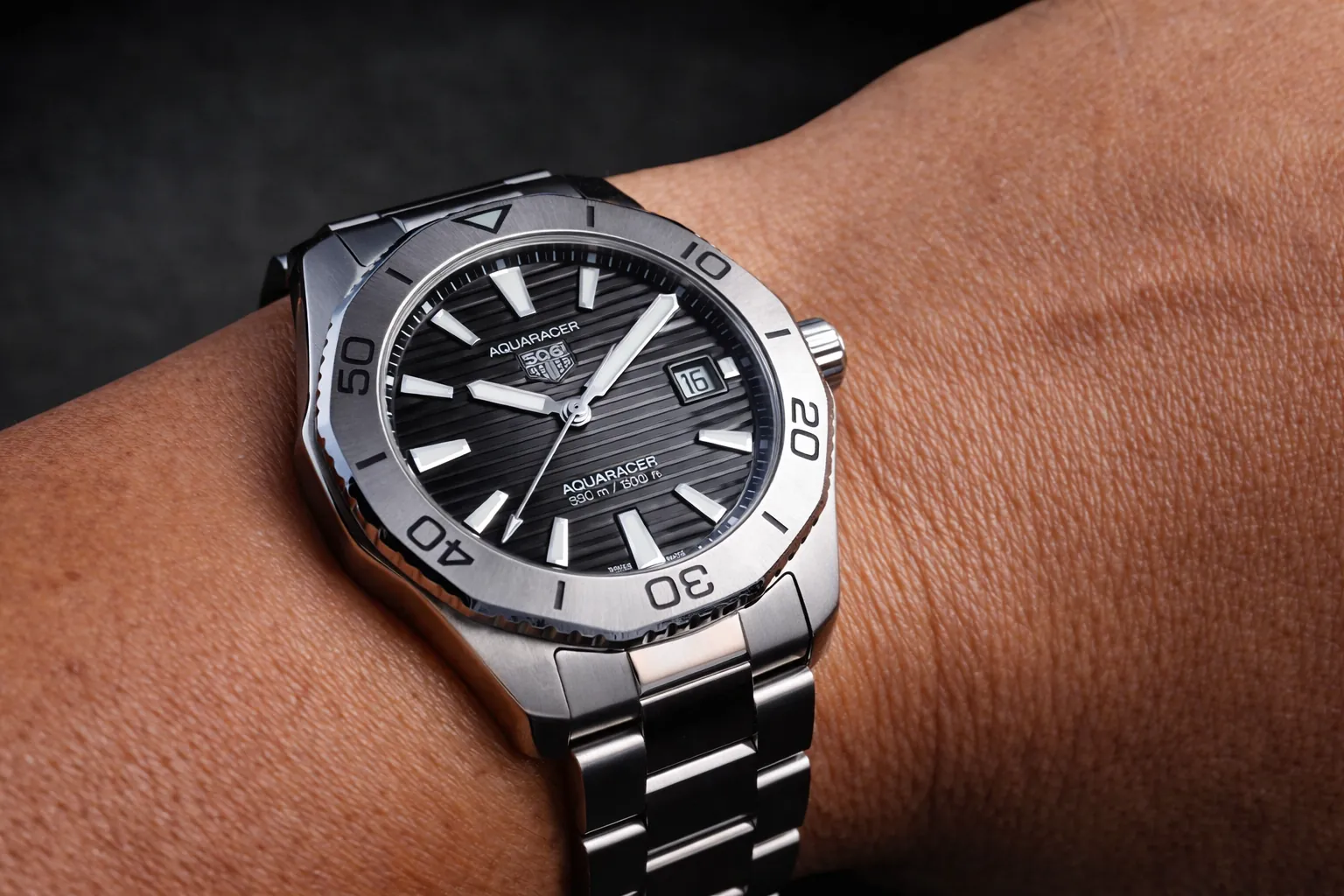 Close-up of TAG Heuer Aquaracer black dial stainless steel watch on wrist